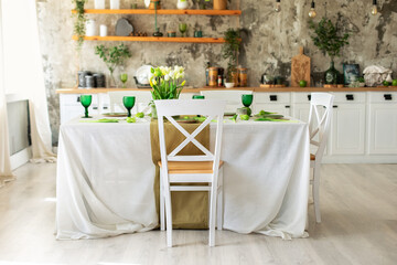 Interior design scandinavian kitchen with table and chair. Cozy Wooden white cuisine decorated with flowers and decor. Kitchen utensils, dishes, plates on shelves. Stylish dining room with furniture	
