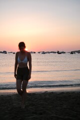 person walking on the beach at sunset