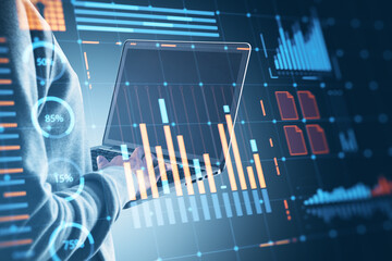 Financial data analysis interface on laptop screen with glowing charts and graphs overlayed.