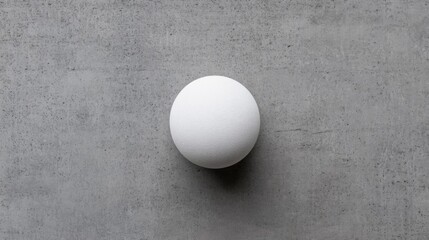 White sphere on grey textured background.