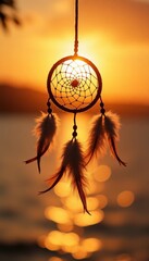 Fototapeta premium Dreamcatcher hanging against the sunset over the sea.
