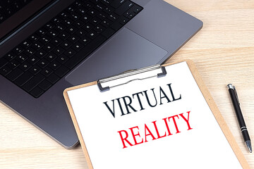 Virtual reality text on a clipboard with a laptop and pen on a wooden desk 