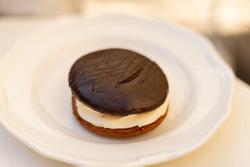 cake, cookie with cream filling and chocolate on a plate