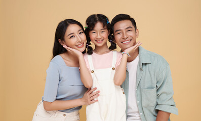 Portrait family of three happy smiling Asian family hugging and love together isolated on nude...