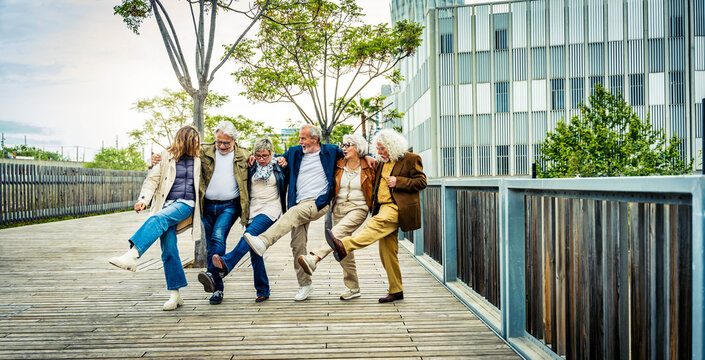 Happy group of senior people having fun walking outdoors