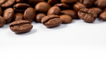 Naklejka premium Roasted coffee beans scattered on white, close-up view, dark, roasted, espresso