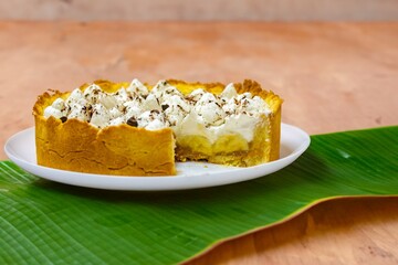 Traditional banoffee cake with banana and caramel sauce filling sprinkled with grated dark chocolate and coffee . English traditional pie