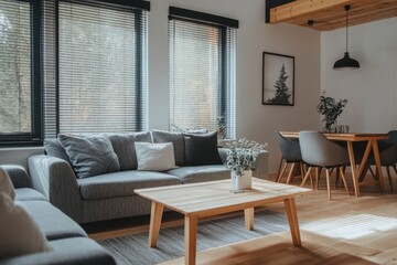 Fototapeta premium Modern living room with gray sofa, wooden coffee table, and dining area.