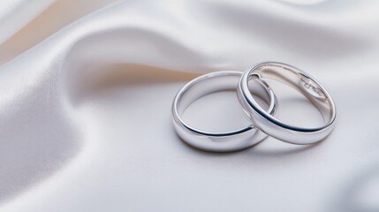 Elegant Intertwined Wedding Rings on Soft White Satin Fabric Reflecting Commitment Love and Unity in a Romantic and Timeless Bridal Setting