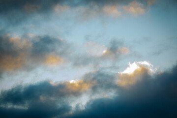 Bare winter trees create intricate silhouettes as the golden light of a sunset glows through their branches. A serene and picturesque winter evening scene.
