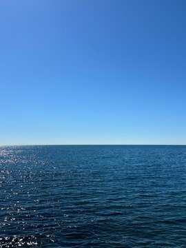 Blue sea calm water and sunny clear sky horizon.