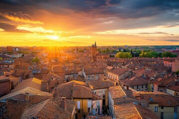 Obraz premium Stunning sunset over the rooftops of an ancient town with vibrant colors illuminating the sky and landscape