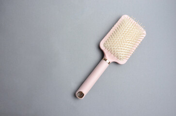 Pink hair comb on a gray background.