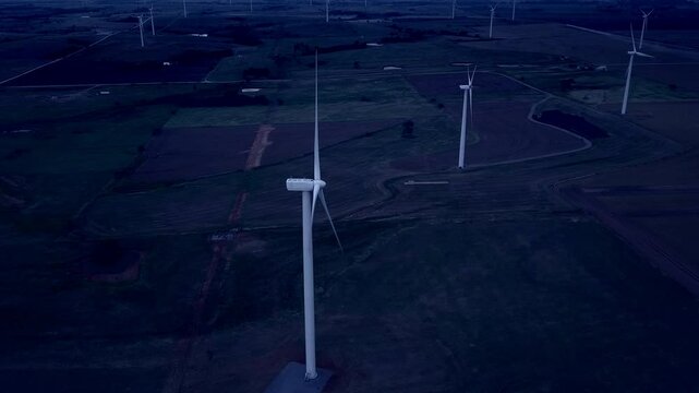 Aerial view of wind turbines at night, slider action drone footage.