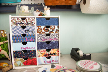 Close-up of assorted fabrics, tools and craft objects on a table in a studio