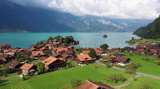 Iseltwald, Switzerland: Aerial drone footage of the famous Iseltwald village and countryside by lake Brienz in the Berner Oberland on a cloudy summer day. Shot with a forward motion
