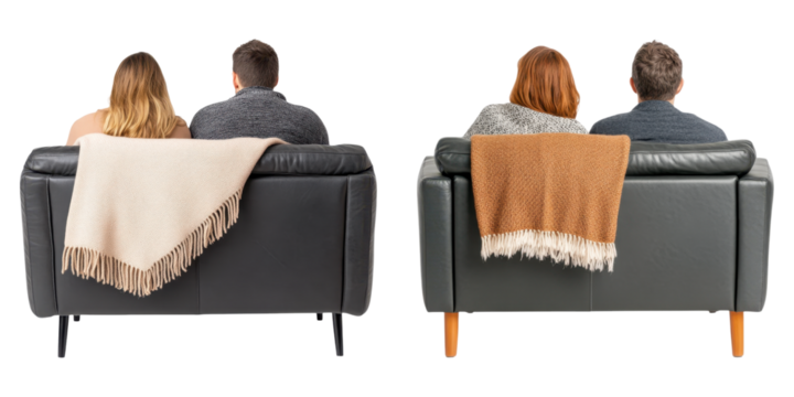 Cozy couple sitting on dark gray leather sofas with warm blankets