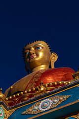 Fototapeta premium Lord Buddha Golden Statue Monastery Sun Ray Blue Sky