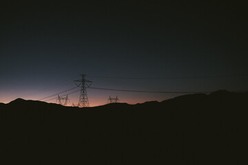 Silhouette of Electricity pylons in a desert landscape at sunset, Chile