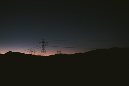 Silhouette of Electricity pylons in a desert landscape at sunset, Chile