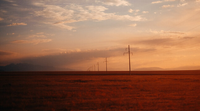 Row of Electricity pylons in desert landscape at sunset, Kazakhstan
