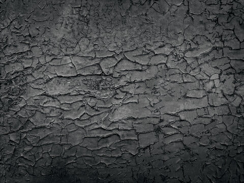 old wall painted with black paint that has cracked with age
