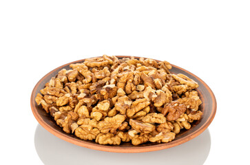 Shelled walnuts on a clay plate, close-up, isolated on a white background.