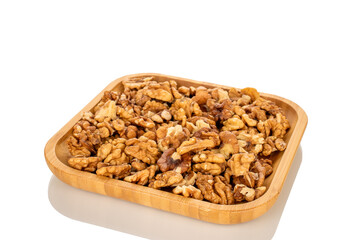 Shelled walnuts on a wooden plate, close-up, isolated on a white background.