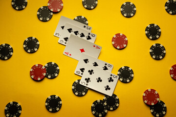 Poker cards with a good winning combination high card are on a yellow table with chips. The concept...