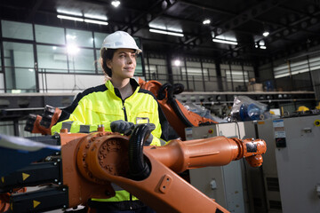 Fototapeta premium Portrait engineer caucasian woman checking arm robot in factory background 
