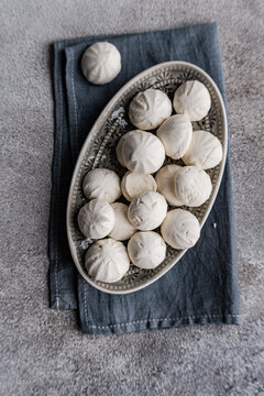 Close-up overhead view of a dish of homemade vanilla zephyrs (Russian marshmallows) on a folded napkin
