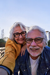 Happy caucasian senior couple taking a selfie outdoors together, enjoying the retired life and love...