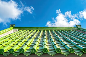 Fototapeta premium Bright green tiled roof under a blue sky with fluffy white clouds