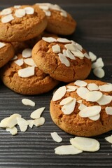 Tasty cookies with almond flakes on wooden table, closeup