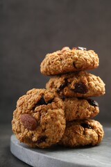 Delicious oatmeal cookies with raisins and nuts on grey table, closeup
