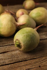 Whole fresh turnips on wooden table, closeup