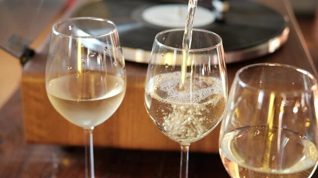 bubbles of French champagne or prosecco in a glass, Pour white wine, champagne or prosecco into a glass from a bottle for an aperitif at home