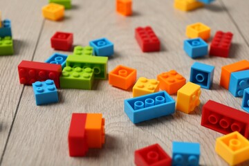 Construction toy. Colorful building bricks on wooden background, closeup
