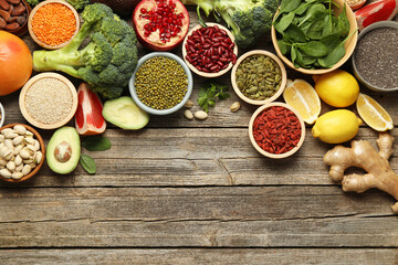 Different superfood products on wooden table, flat lay. Space for text