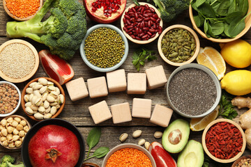 Different superfood products and blank cubes on wooden table, flat lay. Space for text