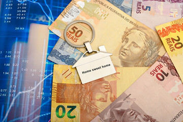 Fototapeta premium a house-shaped keychain made of Brazilian money with the text home sweet home
