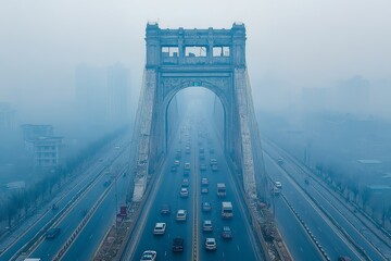 Fototapeta premium Traffic flows beneath a foggy archway in a busy city during early morning hours