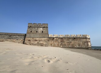 Frog profile view of the Great Wall of China easternmost point where the wall meets the Yellow Sea, Shanhai pass ("Shanhaiguan"), Hebei, China, low tide, beach