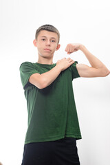 A portrait of a young man in a green shirt flexing his arm. He displays a confident expression. The image is clean and simple, ideal for health or fitness concepts.