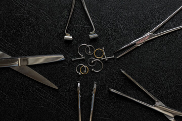 Pinzas y joyas de piercing en mesa