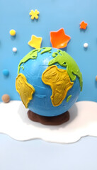 Obraz premium Handmade, children's art. Planet earth on a blue background, craft clay, with white tones
