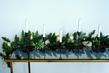 New Year's decor made of glass on a table with candles.