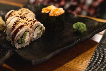 a portion of rolls with eel on a plate in a restaurant