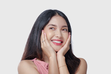 Fototapeta premium Excited young Asian woman wearing pink dress with a joyful expression, isolated by white background.