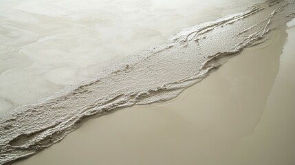 Fresh concrete pouring onto smooth surface creating textured pattern.